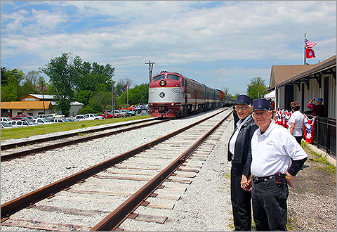 Conductors standing beside train tracks